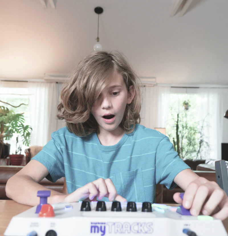 Child playing with a Blipblox myTRACKS at a dining table in a home setting