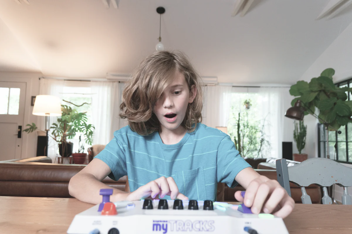 Child playing with a Blipblox myTRACKS at a dining table in a home setting