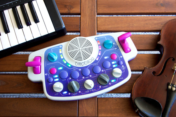 Blipblox SK2 on wood bench with keyboard and violin