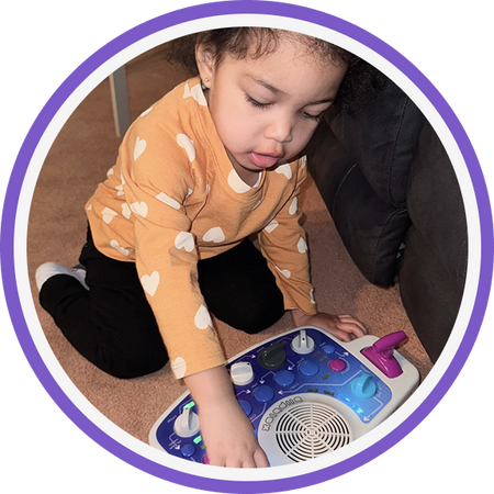 Child playing with a Blipblox SK2 instrument on the floor